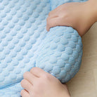 Hands holding a blue textured dog cooling mat with a honeycomb pattern, ideal for pet comfort and temperature regulation. Perfect for summer use.