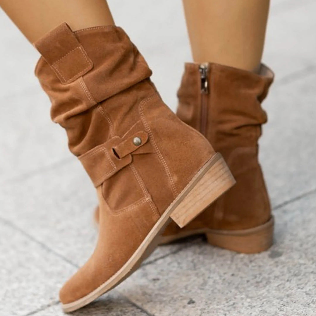 Brown suede ankle boots with slouchy design and wooden block heel, featuring side zipper and strap detail, perfect for casual fall fashion.