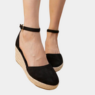 Black espadrille wedge sandals with ankle strap, featuring a jute platform sole. Perfect for summer fashion and casual wear.