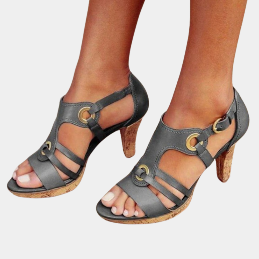 Gray strappy high-heeled sandals with cork soles, featuring gold buckle accents. Stylish women's footwear for summer fashion and casual outings.