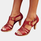 Red strappy high heel sandals with cork heel, featuring gold buckle accents. Perfect for summer fashion, women's footwear, stylish open-toe design.