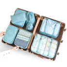 Open suitcase with blue travel packing cubes, neatly organized with clothes and accessories, ideal for efficient luggage organization and travel packing.