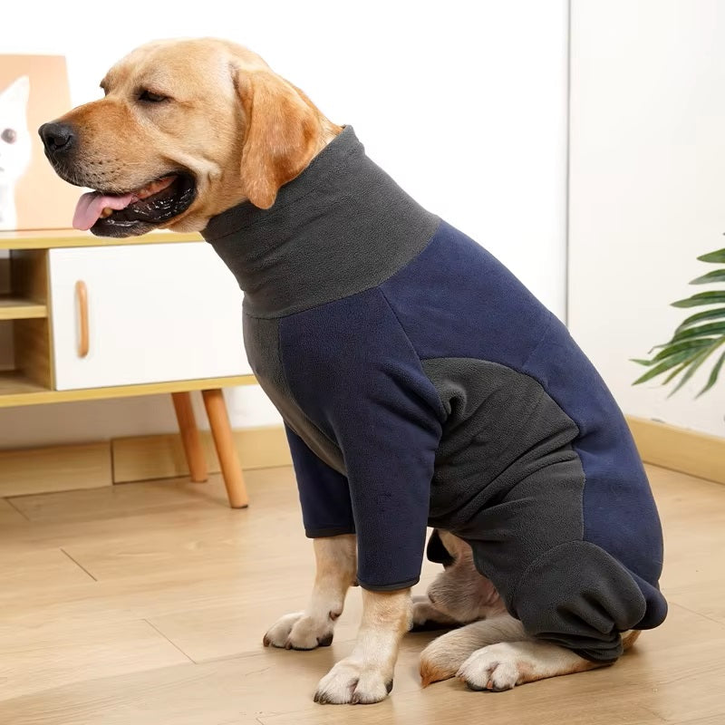 Golden Retriever wearing a cozy blue and gray fleece dog jacket, sitting indoors on wooden floor. Pet apparel, dog clothing, warm dog coat.