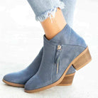 Blue suede ankle boots with side zipper, wooden block heel, and frayed hem jeans. Stylish women's footwear, comfortable design, trendy fashion.