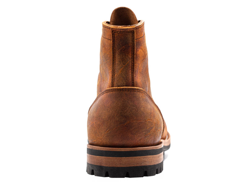 Brown leather boot with rugged sole, rear view. Durable, stylish footwear for men. Perfect for outdoor adventures and casual wear. High-quality craftsmanship.