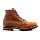 Brown leather Coach Rambler boot with rugged sole, lace-up design, and cap toe. Durable men's footwear, perfect for outdoor and casual wear.