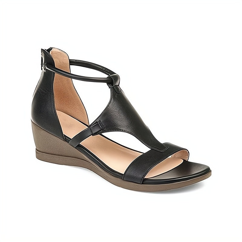 Black leather wedge sandal with ankle strap, open toe, and cushioned footbed. Stylish women's footwear for summer fashion and comfort.