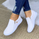 White slip-on women's sneakers with zipper detail, breathable and casual, perfect for spring and summer fashion. Comfortable flat vulcanized shoes.