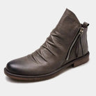 Gray leather ankle boot with side zipper, ruched design, and wooden sole. Stylish men's footwear, perfect for casual and formal wear.