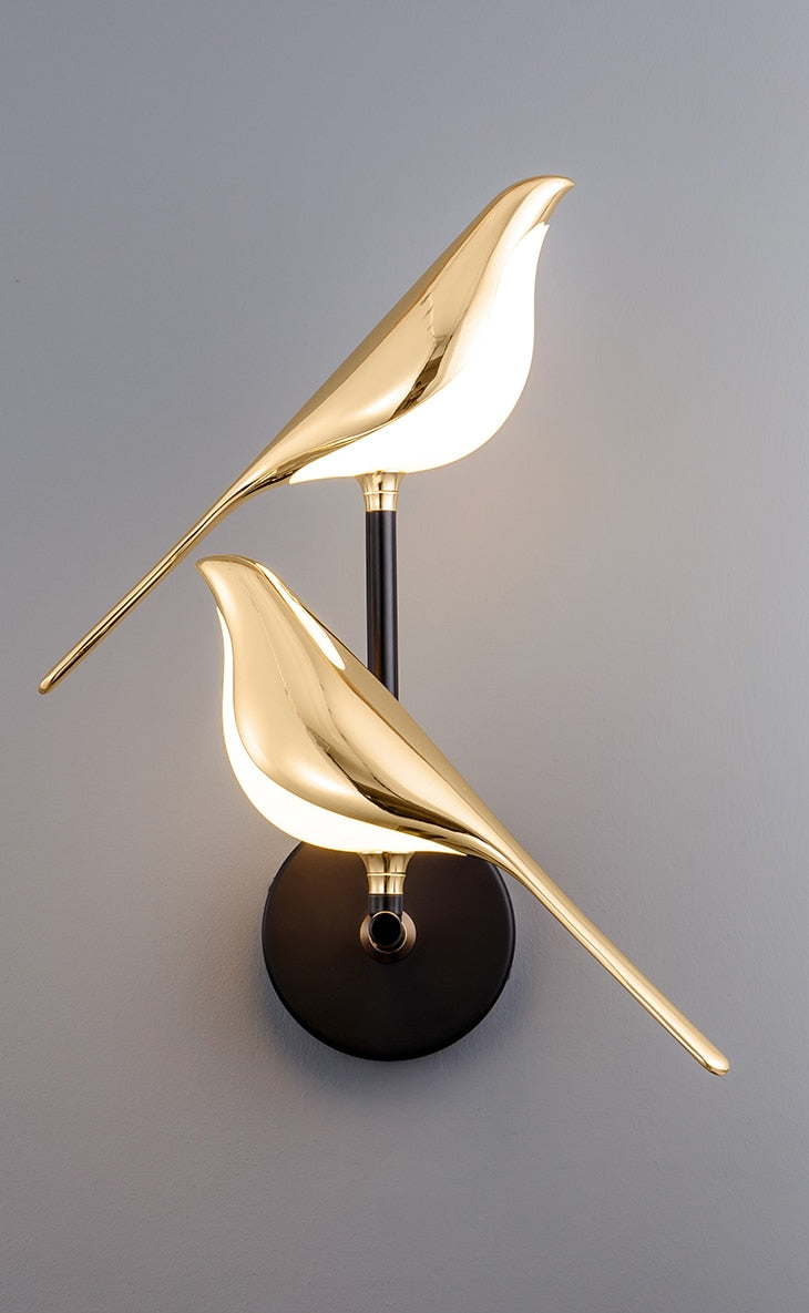 Gold bird wall sconce with dual bird-shaped lights on a black base, modern home decor, elegant lighting fixture, contemporary interior design.