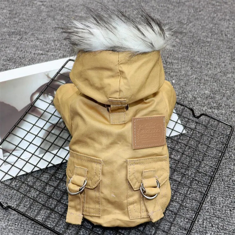 Dog winter coat with faux fur hood, tan color, featuring buckle details and pockets, displayed on a wire rack. Pet apparel, warm dog jacket.