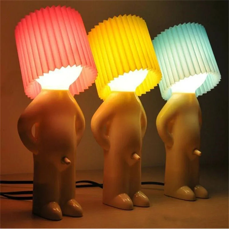 Colorful human-shaped table lamps with pleated shades in red, yellow, and blue. Unique modern home decor lighting for living room or bedroom.