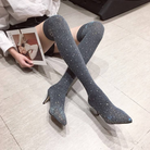 Woman wearing sparkly over-the-knee high heel boots, sitting on a tiled floor, holding a fashion magazine. Stylish footwear, trendy fashion accessory.