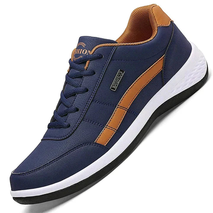 Men's navy blue casual sneaker with orange accents, white sole, and black outsole. Stylish, comfortable footwear for everyday wear. Fashionable men's shoe.