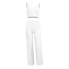White fuzzy two-piece loungewear set featuring a sleeveless crop top and high-waisted wide-leg pants, perfect for cozy, stylish comfort.