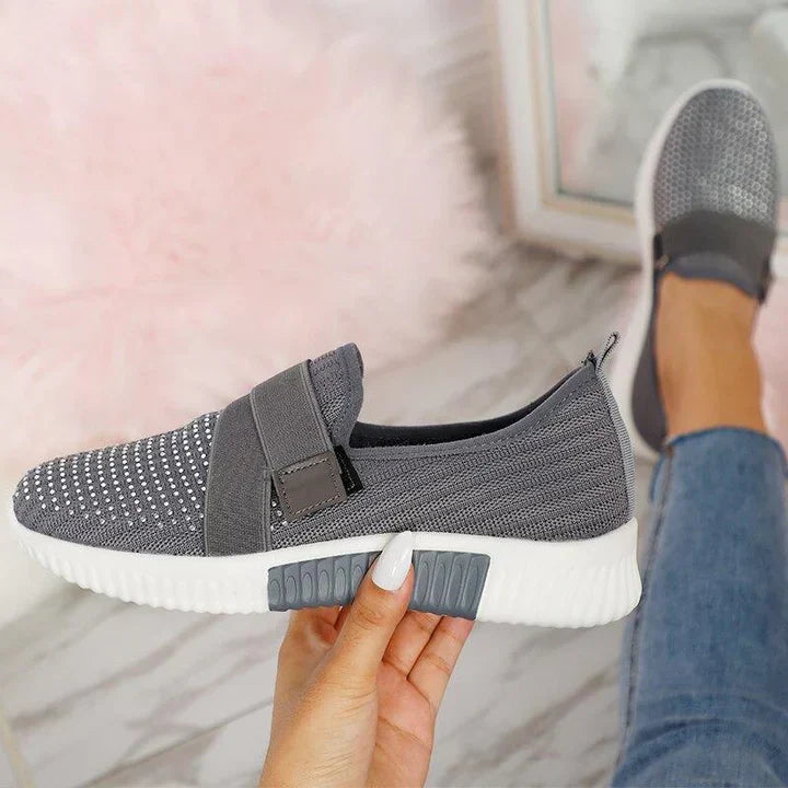 Gray slip-on sneakers with Velcro strap, knitted upper, and cushioned sole for improved posture. Women's casual footwear, comfortable and stylish.