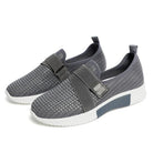 Gray slip-on sneakers with Velcro strap, breathable mesh design, and white sole. Ideal for improved walking posture and casual wear.