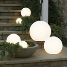 Outdoor LED globe lights on stone steps, glowing spheres for garden decoration, energy-efficient lighting, modern landscape design, evening ambiance.