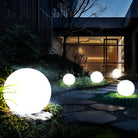 Glowing LED sphere lights illuminate a modern outdoor garden path at night, creating a serene ambiance. Perfect for landscape lighting and decor.