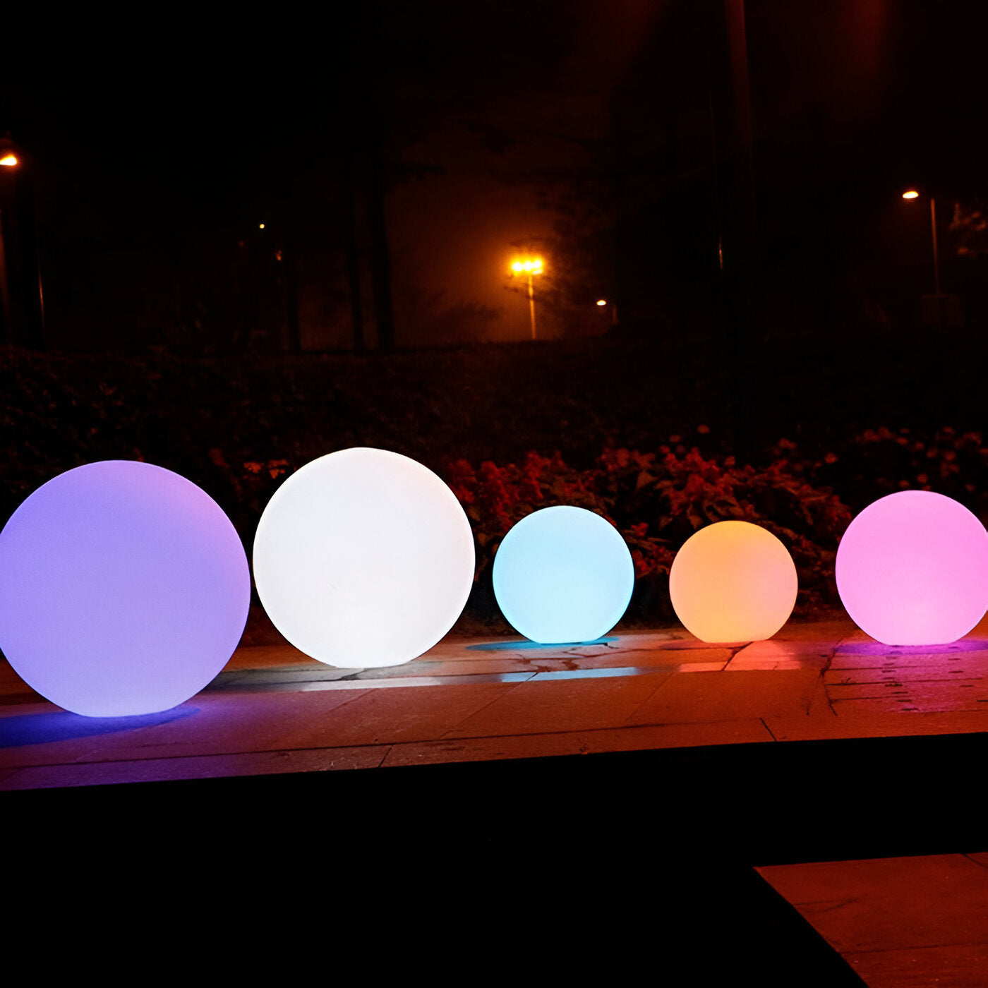 Colorful LED outdoor decorative spheres glowing at night, featuring vibrant hues of purple, white, blue, orange, and pink, ideal for garden ambiance.