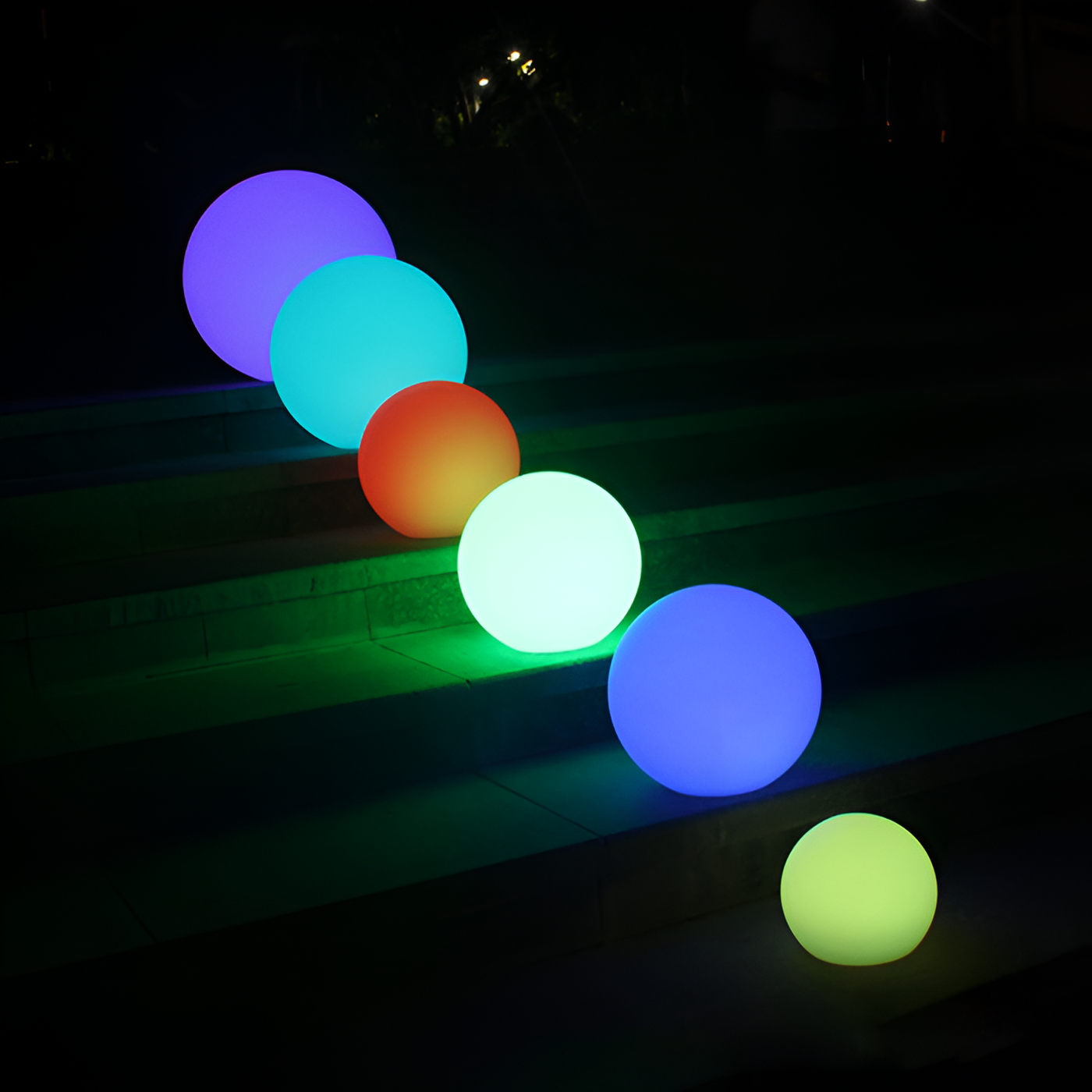 Colorful LED spheres illuminating outdoor steps at night, featuring vibrant hues of blue, green, and red. Perfect for garden or patio decoration.