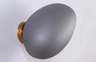 Modern wall light with a sleek, matte black oval shade and a gold base, perfect for contemporary home decor and ambient lighting solutions.