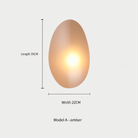 Amber pebble-shaped wall light, Model A, 35cm length, 22cm width. Modern home decor, ambient lighting fixture, minimalist design.