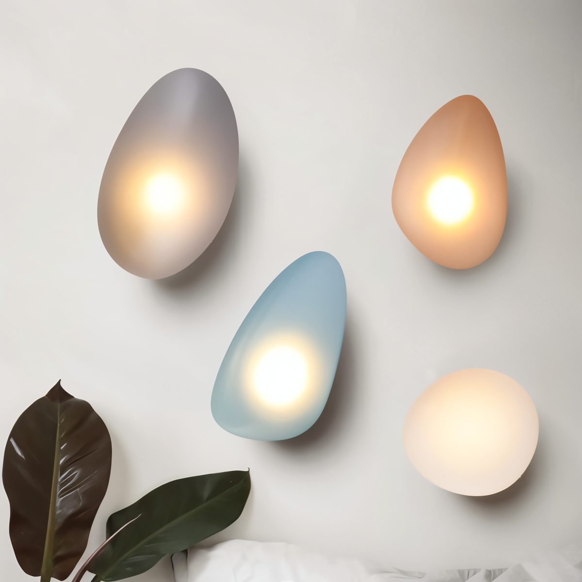 Modern pebble-shaped wall lights in soft hues of gray, blue, peach, and cream, illuminating a minimalist interior space. Stylish home lighting decor.