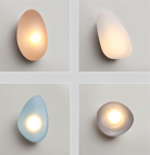 Modern pebble-shaped wall lights in soft hues: beige, white, blue, and gray. Elegant LED lighting fixtures for contemporary home decor.