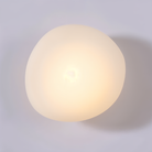 Modern pebble-shaped wall light with warm glow, minimalist design. Ideal for home decor, ambient lighting, energy-efficient LED wall fixture.