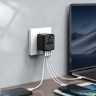 Multi-port USB wall charger with five connected cables, charging multiple devices including a laptop and smartphone on a desk. Efficient power hub.