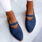 Blue woven leather women's slip-on shoes with pointed toes, worn with white pants. Stylish, comfortable footwear for casual or formal occasions.