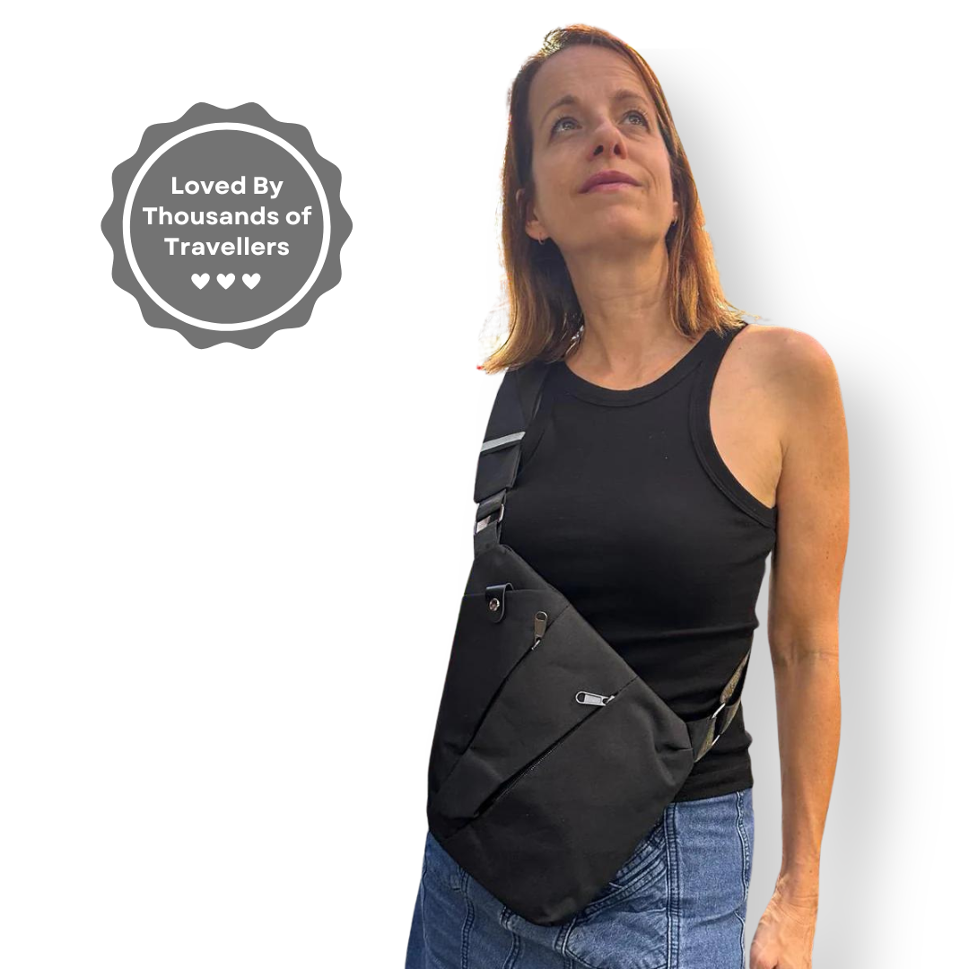 Woman wearing a black crossbody travel bag with adjustable strap, ideal for secure travel. "Loved by Thousands of Travellers" badge displayed.