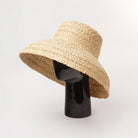 Wide-brim raffia straw hat for women, perfect for summer beach vacations. Stylish sun protection with flat top design. UV protection hat.