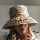 Wide-brimmed raffia straw hat for women, perfect for summer beach vacations. Stylish sun protection with a flat top design.