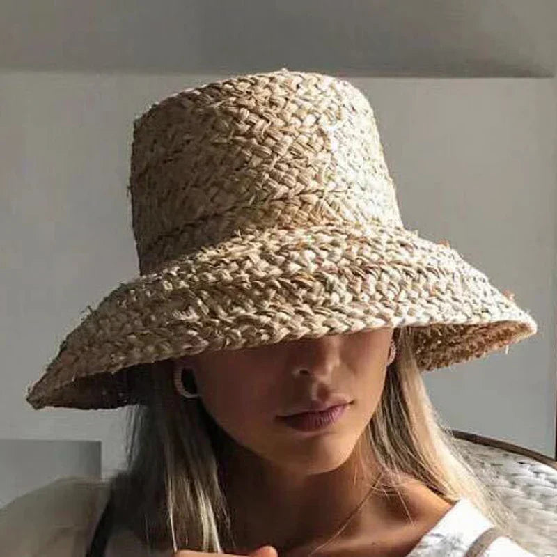 Wide-brimmed raffia straw hat for women, perfect for summer beach vacations. Stylish sun protection with a flat top design.