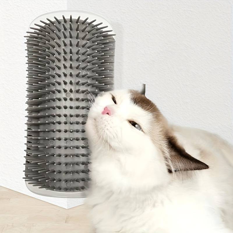 Cat rubbing against gray wall-mounted grooming brush for self-grooming and fur care.