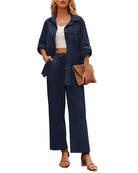 Woman wearing a stylish navy blue two-piece outfit with a white top, holding a woven clutch. Fashionable casual attire, perfect for summer.