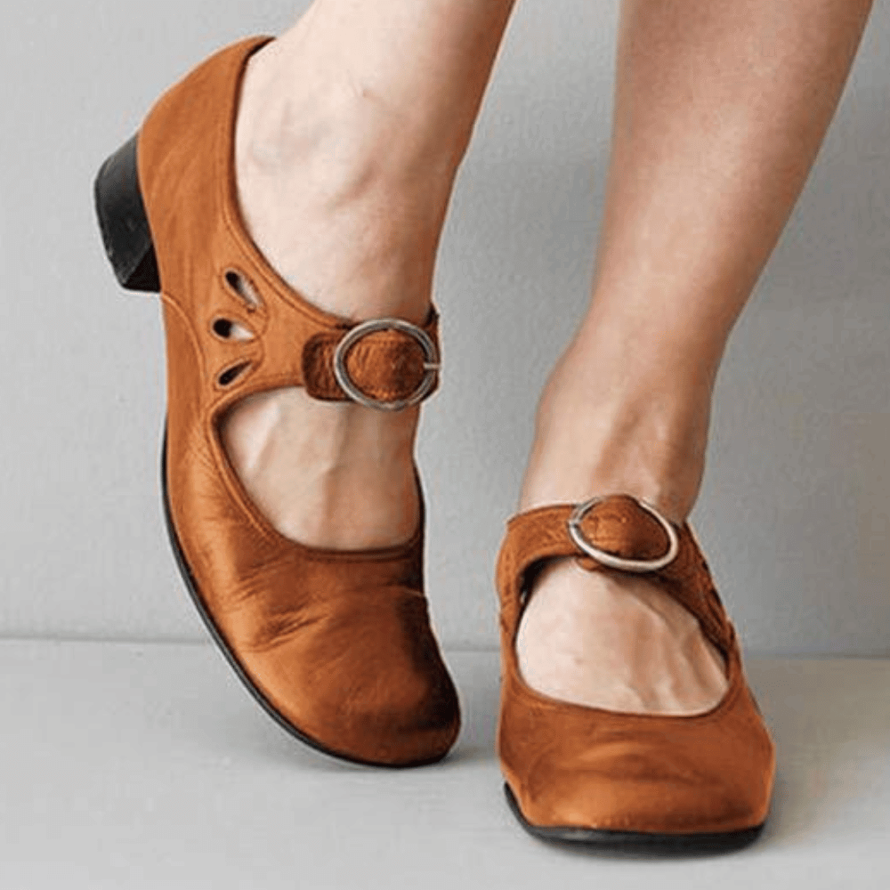 Brown leather Mary Jane shoes with buckle strap, low heel, and cutout design, perfect for casual wear. Comfortable women's footwear, stylish and versatile.