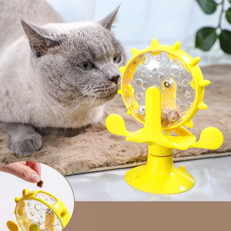 Cat playing with interactive yellow spinning toy featuring suction cup base and treat dispenser, promoting pet engagement and mental stimulation.