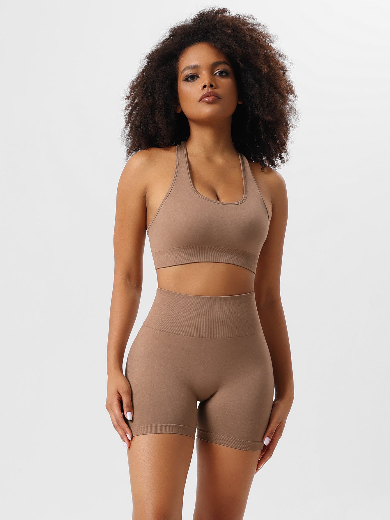 Woman wearing a brown seamless workout set, featuring a sports bra and high-waisted shorts, ideal for yoga and fitness. Comfortable activewear.