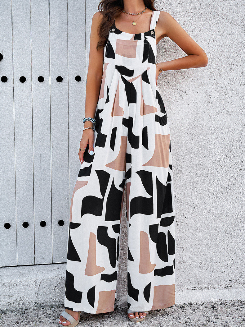 Woman wearing abstract print wide-leg jumpsuit with geometric patterns, standing against a textured wall. Fashionable summer outfit, casual style.