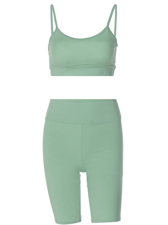 Mint green women's activewear set featuring a spaghetti strap sports bra and high-waisted biker shorts. Perfect for yoga, gym, or casual wear.