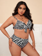 Woman wearing a zebra print bikini set with high-waisted bottoms, posing confidently indoors. Fashionable swimwear, plus-size model, summer style.