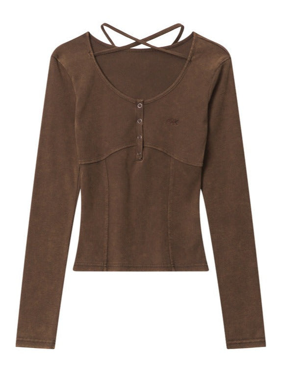 Brown long-sleeve women's top with button details and cross-back straps, featuring a fitted design. Perfect for casual and stylish outfits.