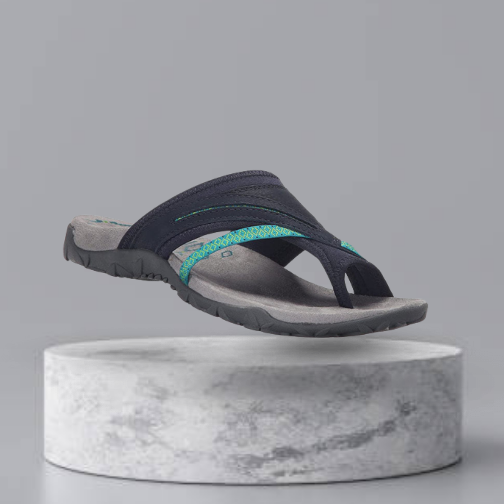 Navy blue and teal men's outdoor sandal with durable sole, displayed on a marble pedestal. Ideal for hiking and casual wear.