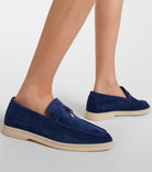 Blue suede loafers with beige soles on feet, showcasing a stylish and comfortable design. Perfect for casual wear. Fashion footwear, men's shoes.