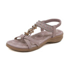 Women's taupe sandal with rhinestone embellishments, cushioned sole, and elastic ankle strap. Stylish summer footwear, perfect for casual wear.