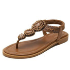 Brown beaded women's sandal with decorative floral design, flat sole, and elastic ankle strap. Perfect for summer fashion and casual wear.