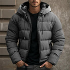 Gray men's puffer jacket with hood, zipper closure, and pockets, ideal for winter fashion.